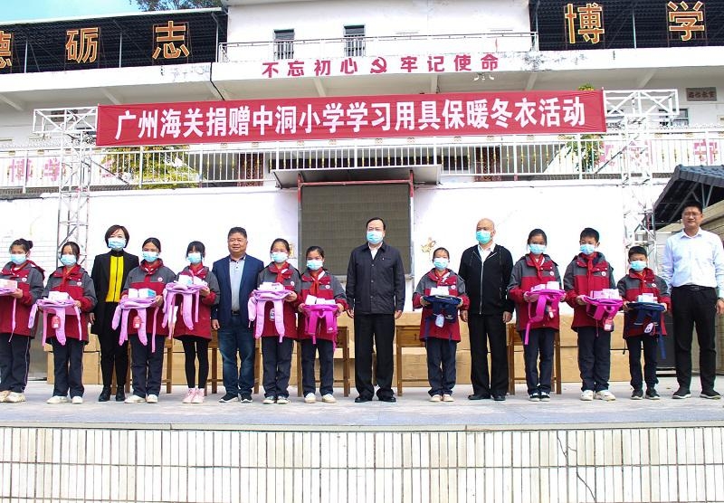 图为:丁吉豹关长代表广州海关向中洞小学全体学生赠送书包,文具等